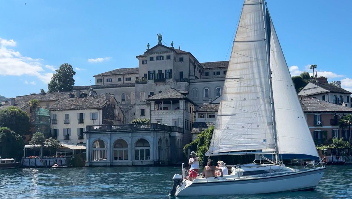 A sailboat passes ahead outside of Isola di San Giulio in Lago d'Orta.
