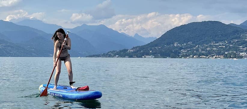 Me standing on a blue paddle board in Lake Orta.