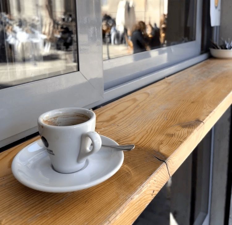 An empty cappuccino cup sits on a ledge outside the "We Love Coffee" bar in Saint Alessandro Piazza