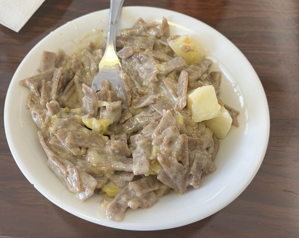 A bowl of Pizzoccheri pasta with potatoes and cabbage.