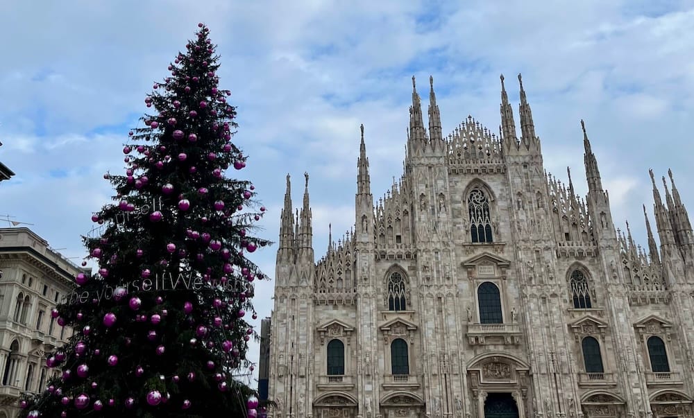 The Duomo in Milano with a Christmas tree by its side.