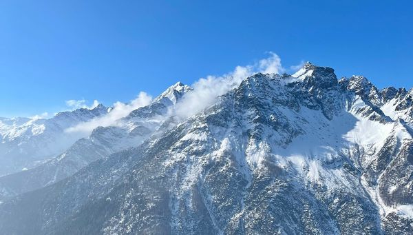 A snow-capped mountain on a sunny day. 